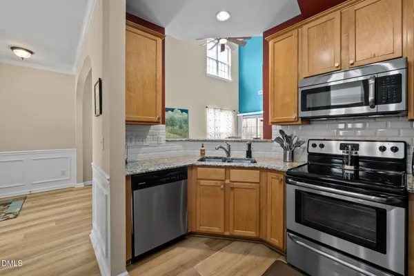 a kitchen with stainless steel appliances a stove microwave and sink