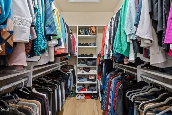 a view of walk in closet with clothes and shoes