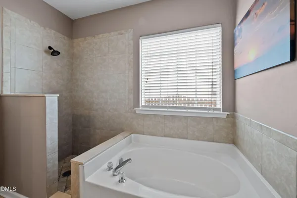 a white bath tub sitting in a bathroom next to a window