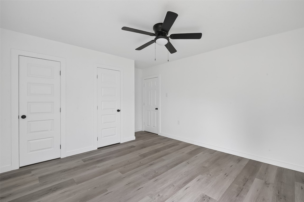 4933 Doolittle Boulevard Houston, TX 77033 - Photo 17 of 28 a view of a room with wooden floor ceiling fan and window