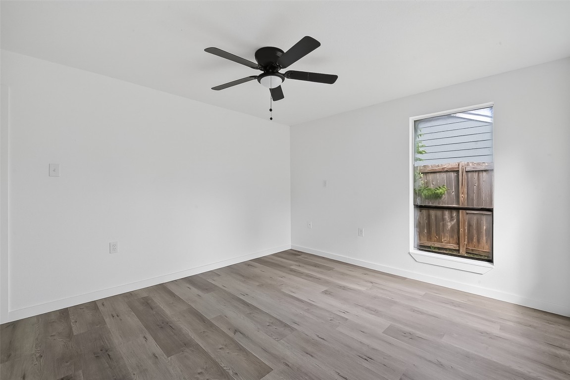 4933 Doolittle Boulevard Houston, TX 77033 - Photo 18 of 28 a view of empty room with wooden floor and ceiling fan