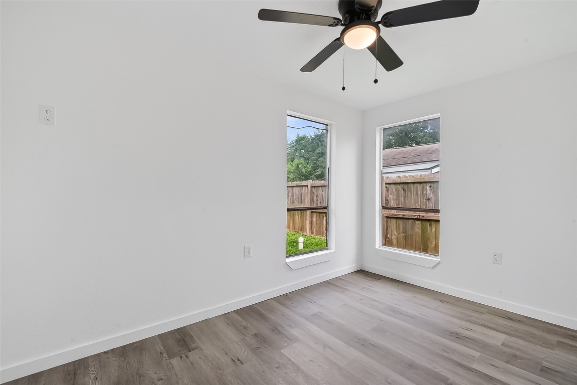 4933 Doolittle Boulevard Houston, TX 77033 - Photo 21 of 28 an empty room with windows and ceiling fan