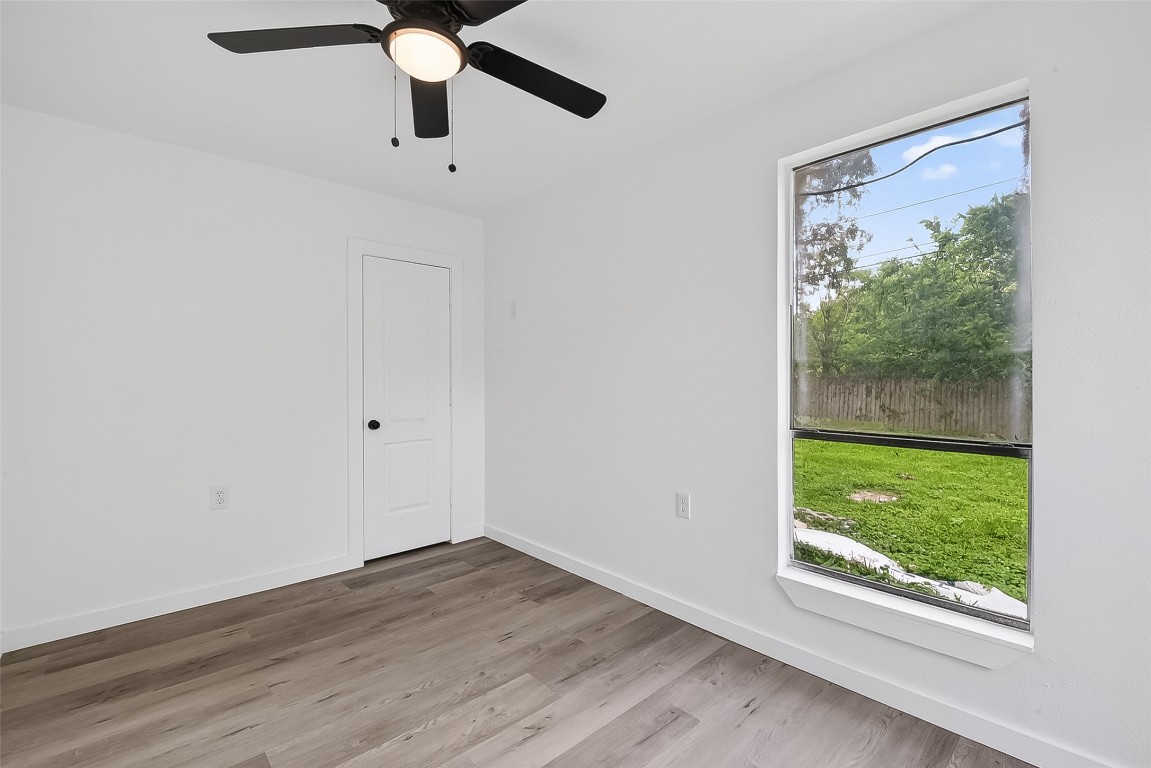 4933 Doolittle Boulevard Houston, TX 77033 - Photo 23 of 28 a view of an empty room with wooden floor and windows