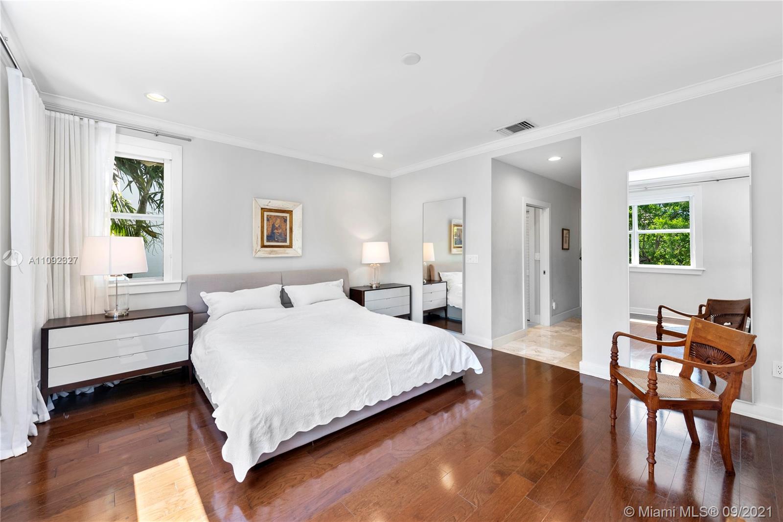 280 Ridgewood Road Key Biscayne, FL 33149 - Photo 18 of 30 a spacious bedroom with a bed a table and chair
