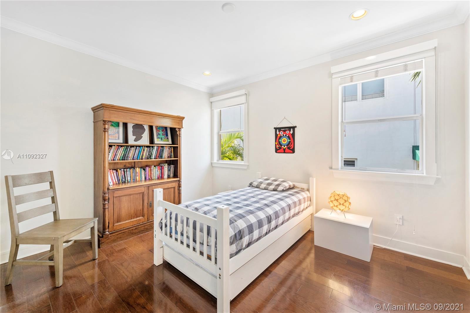 280 Ridgewood Road Key Biscayne, FL 33149 - Photo 24 of 30 a bedroom with a bed and a book shelf