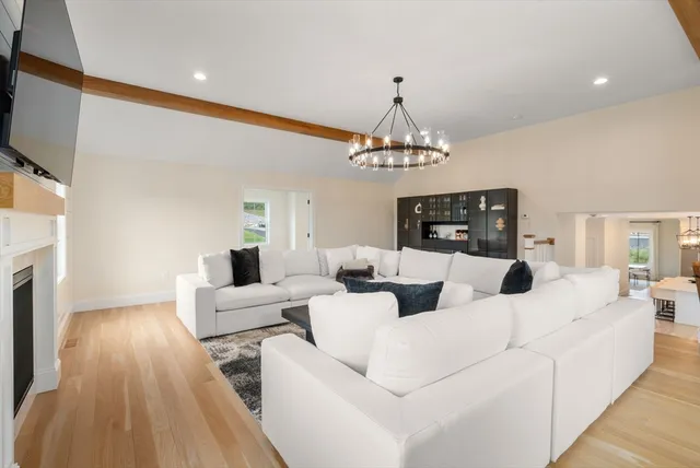 a living room with furniture a chandelier and a fireplace