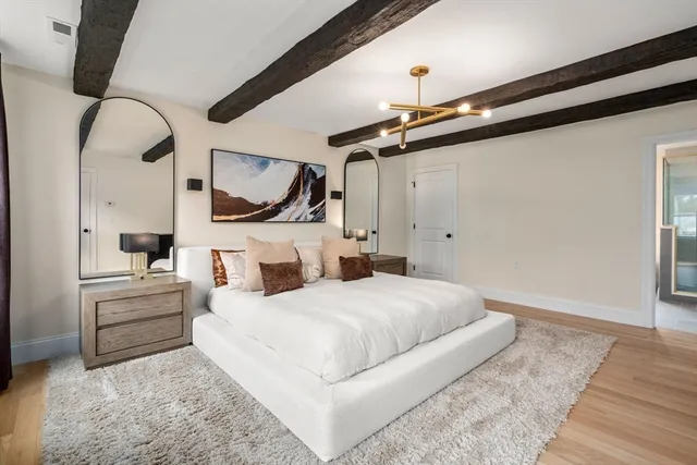 a bedroom with a large bed and a chandelier