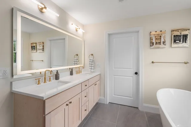 a bathroom with a double vanity sink mirror and bathtub