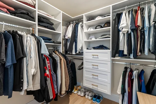 a view of walk in closet with clothes and shoes