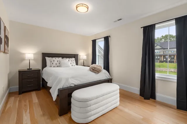 a bedroom with a bed and wooden floor