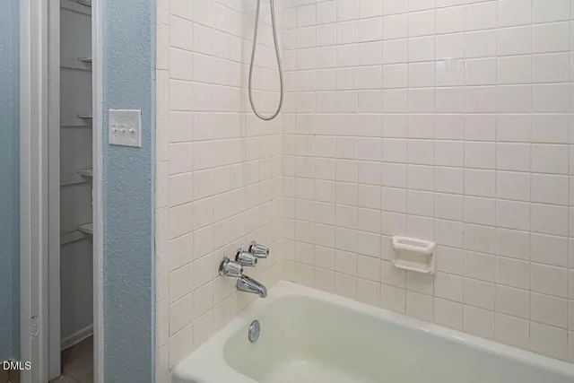 a bathroom with a bath tub with a shower
