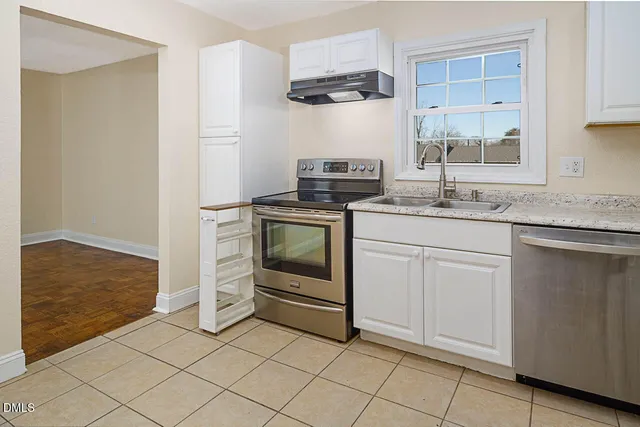 a kitchen with white cabinets appliances and sink