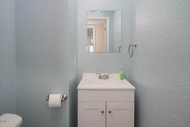 a bathroom with a sink toilet and mirror