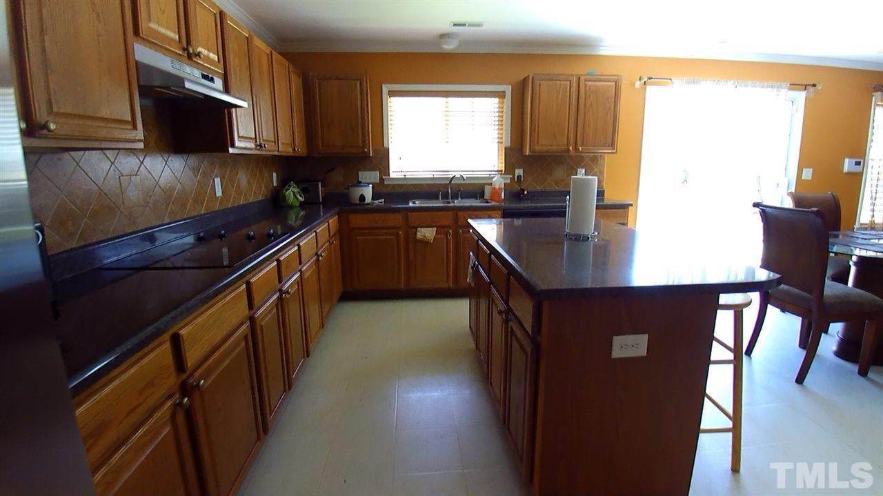 4028 Oatgrass Lane Raleigh, NC 27604 - Photo 5 of 8 a kitchen with stainless steel appliances granite countertop a stove a sink and a microwave