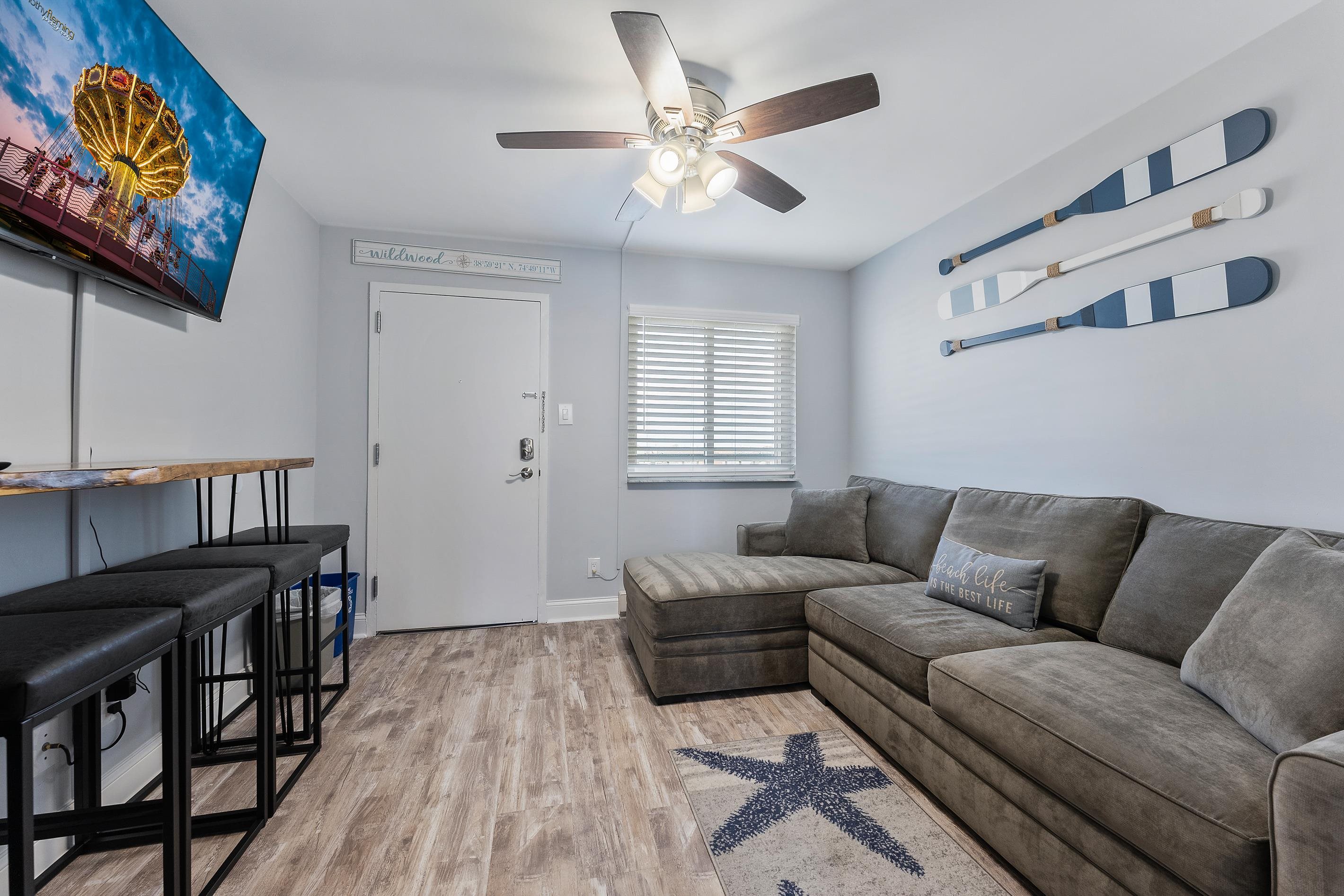 225 East Wildwood Avenue, Unit 505 Wildwood, NJ 08260 - Photo 8 of 24 a living room with furniture and a flat screen tv