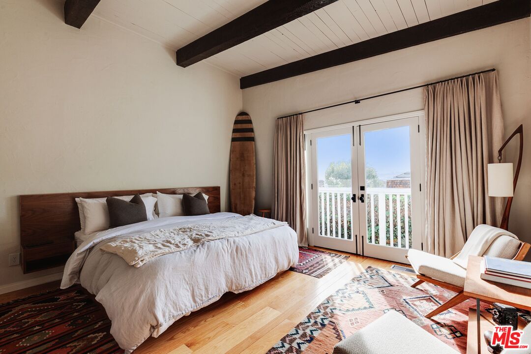 3629 Serra Road Malibu, CA 90265 - Photo 12 of 26 a bedroom with a bed a couch and a large window