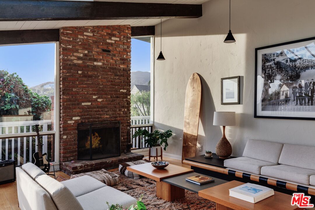 3629 Serra Road Malibu, CA 90265 - Photo 4 of 26 a living room with furniture a fireplace and a flat screen tv