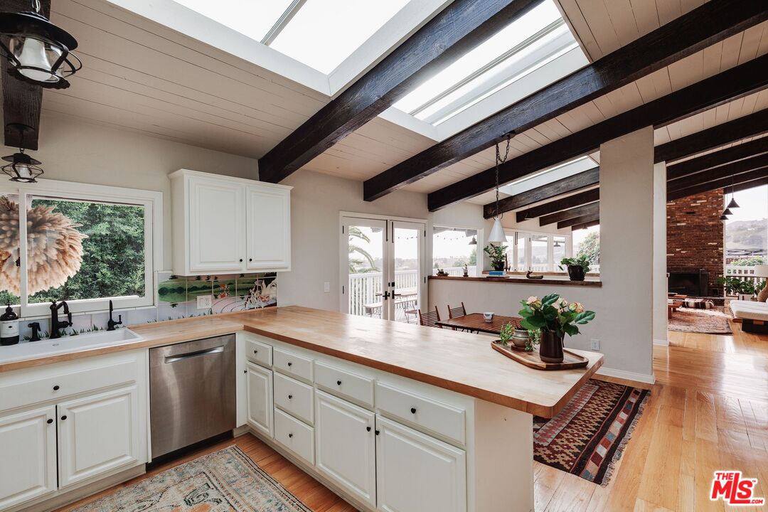 3629 Serra Road Malibu, CA 90265 - Photo 10 of 26 a kitchen with white cabinets and window