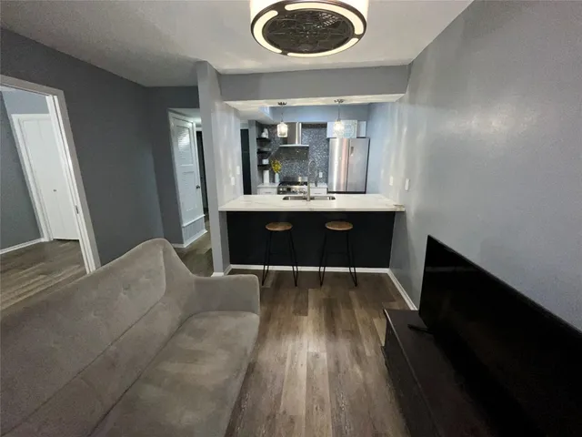 a view of living room and kitchen with wooden floor