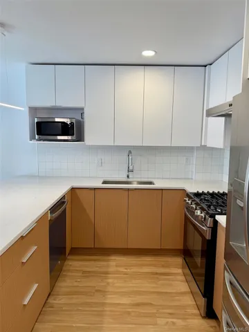 a kitchen with granite countertop a stove a sink and a microwave