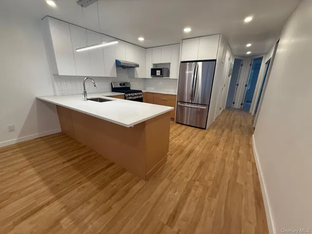a kitchen with stainless steel appliances a refrigerator and a stove top oven