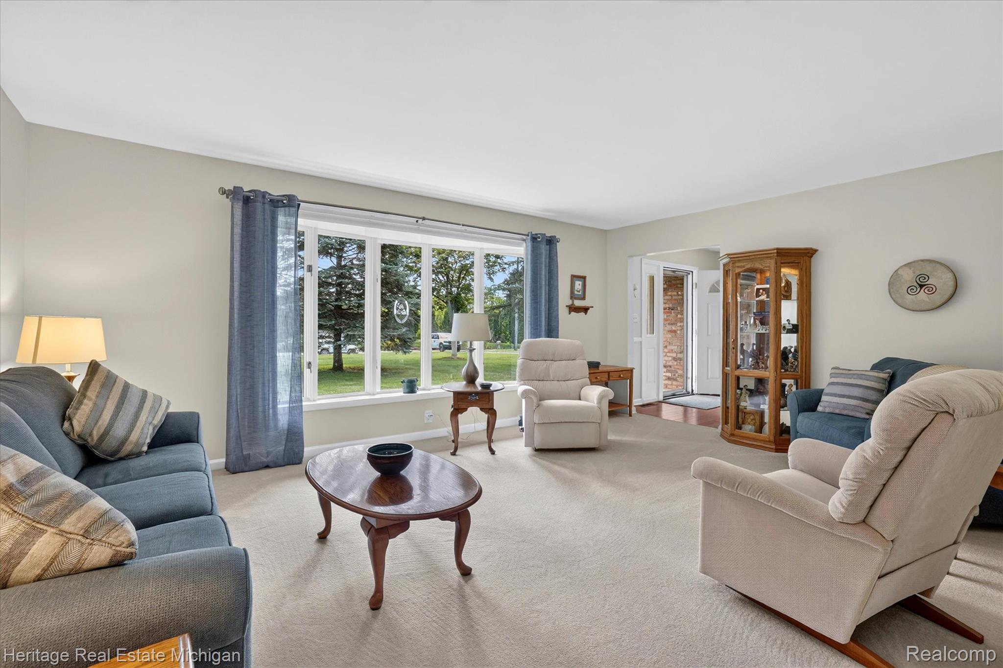 14038 North Hogan Road Linden, MI 48451 - Photo 7 of 53 Living area featuring a large bay window, light neutral wall tones, and carpet flooring