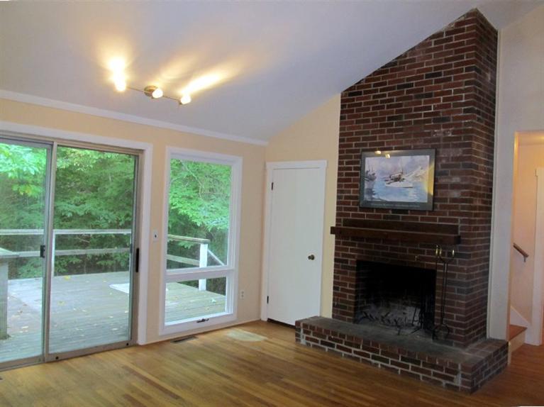 52 F R Lillie Road Woods Hole, MA 02543 - Photo 3 of 17 a view of an empty room with wooden floor fireplace and a window