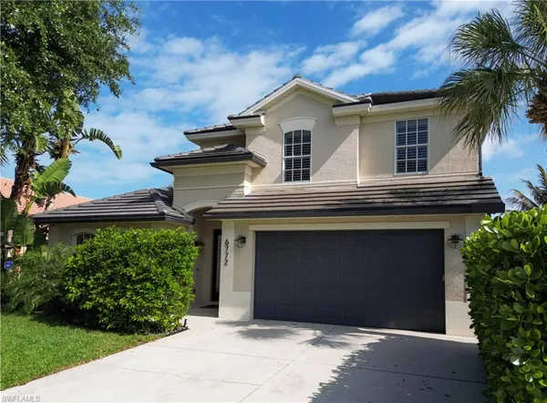 a house that has a lot of plants and palm trees