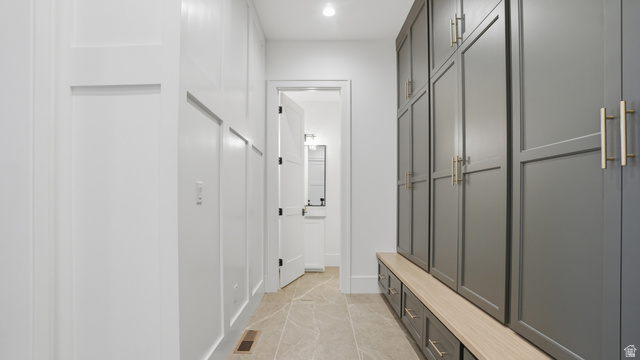 1682 North 1950 W Street, Unit 9 Provo, UT 84604 - Photo 25 of 84 Hallway featuring board-and-batten wall detailing, large format tile flooring, built-in cabinetry with gold-toned hardware, and an integrated bench with storage drawers