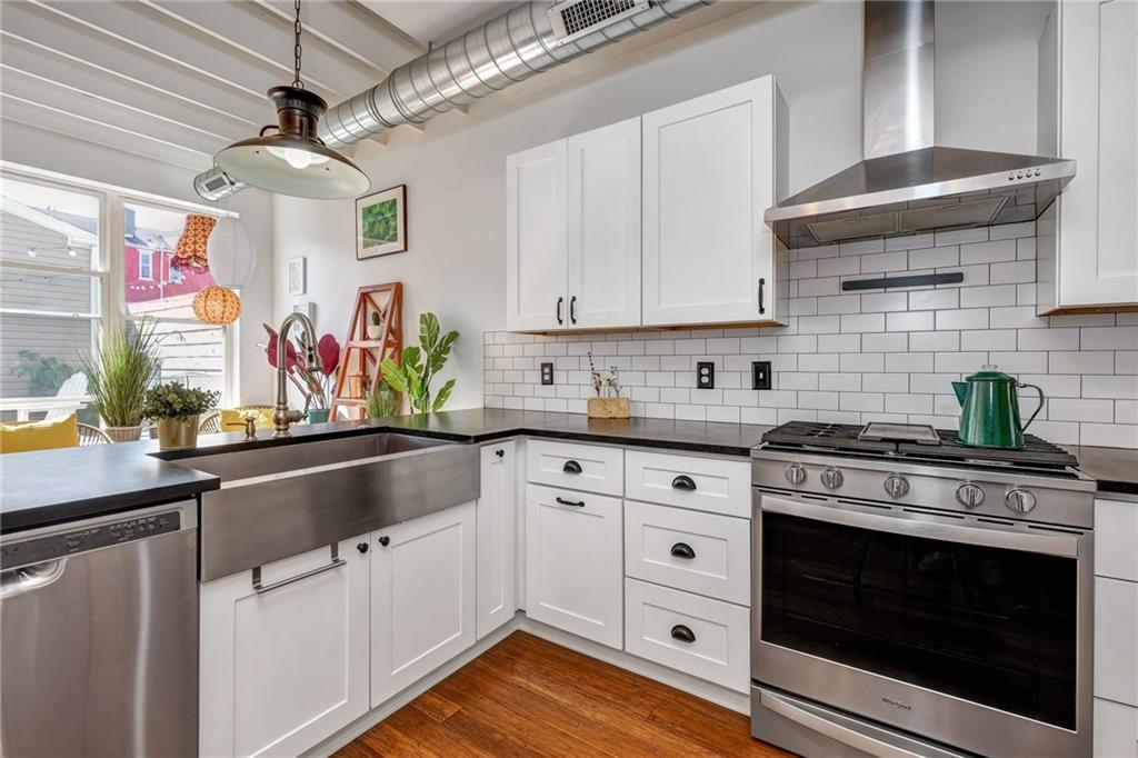 3622 Smallman Street Pittsburgh, PA 15201 - Photo 11 of 25 Close up of the kitchen where the stainless steel farmhouse sink can easily be seen. The home also has a standalone hood above the smart oven. The lights are perfectly styled to fit the color palette of the home.