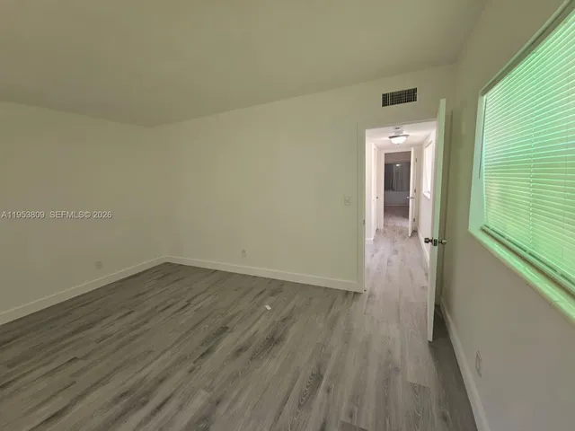 a view of a room with wooden floor and windows
