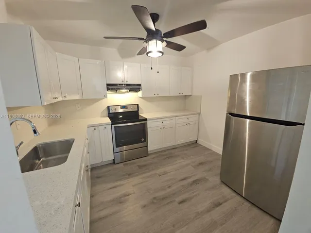 a kitchen with a refrigerator sink and cabinets