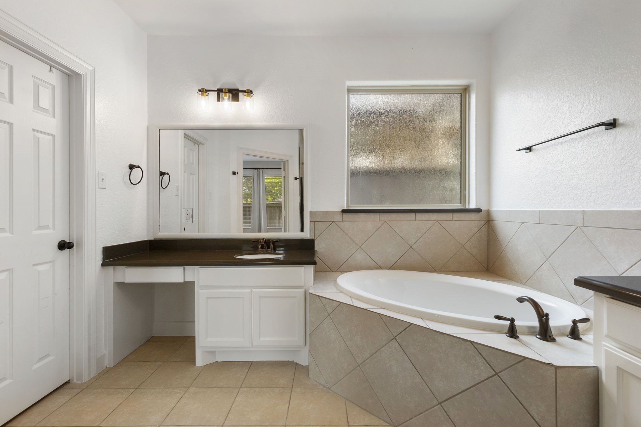 71 Sagamore Ridge Place The Woodlands, TX 77389 - Photo 23 of 34 a bathroom with a tub sink and mirror