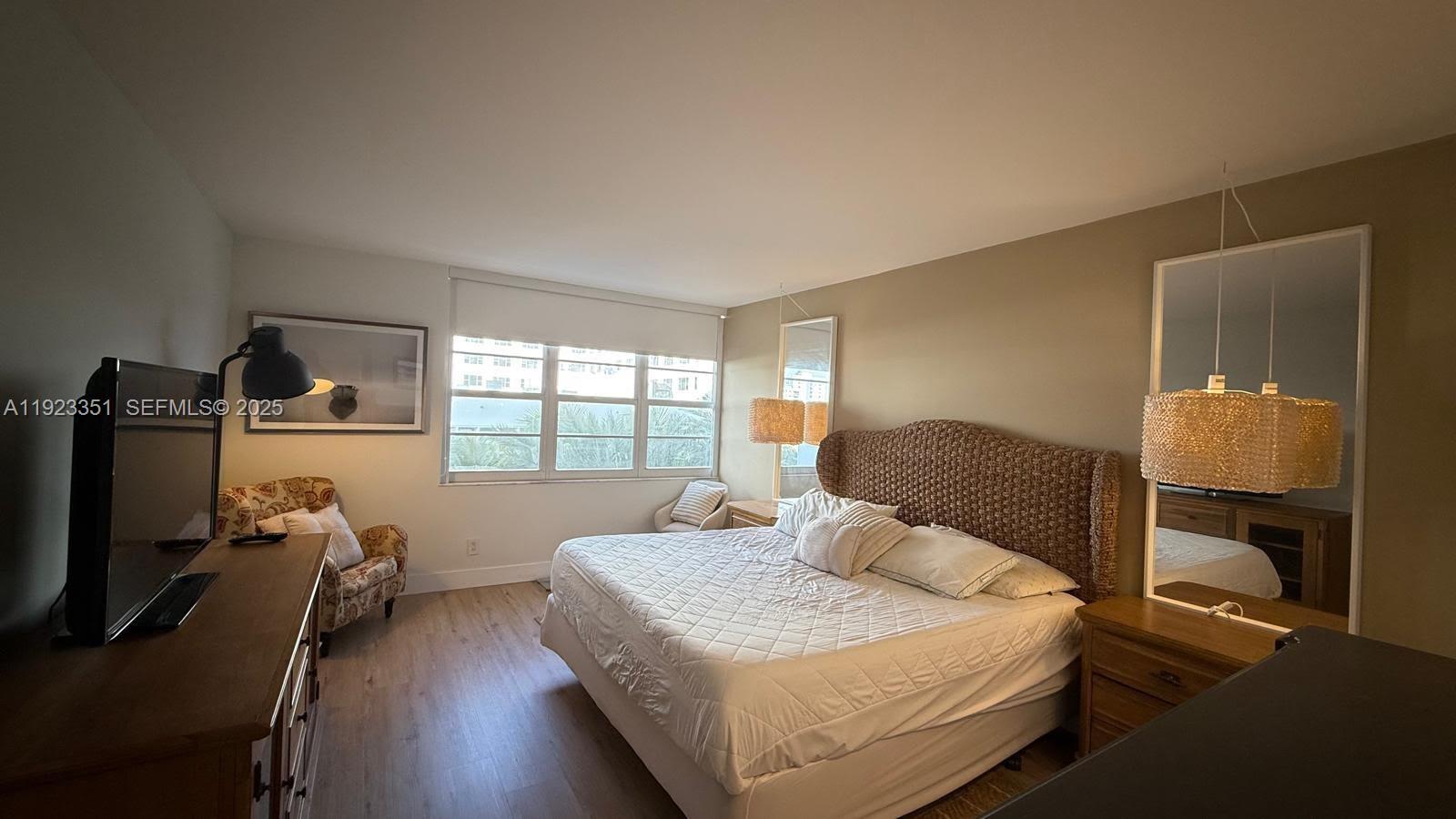 100 Lincoln Road, Unit 410 Miami Beach, FL 33139 - Photo 7 of 18 a bedroom with a bed and wooden floor