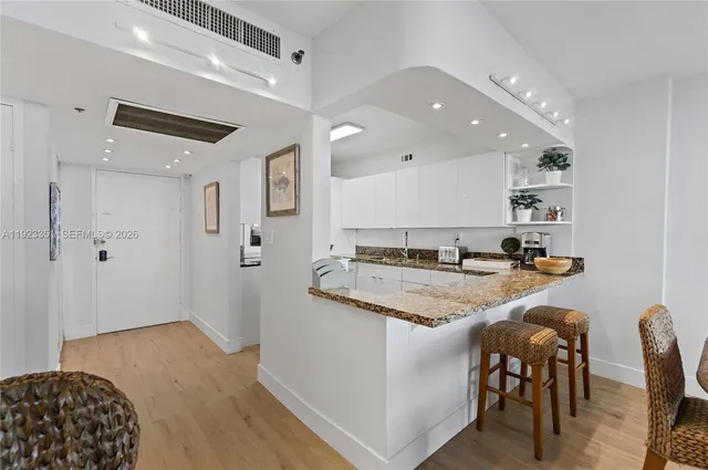 a kitchen with stainless steel appliances granite countertop a sink and a refrigerator