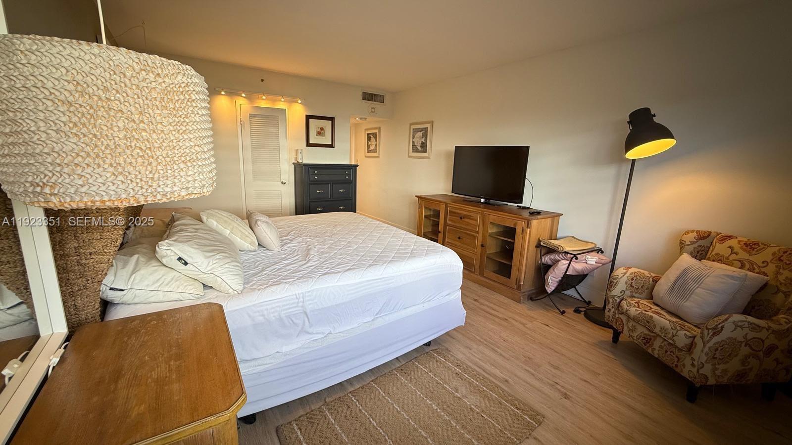 100 Lincoln Road, Unit 410 Miami Beach, FL 33139 - Photo 10 of 18 a bedroom with a bed and wooden floor