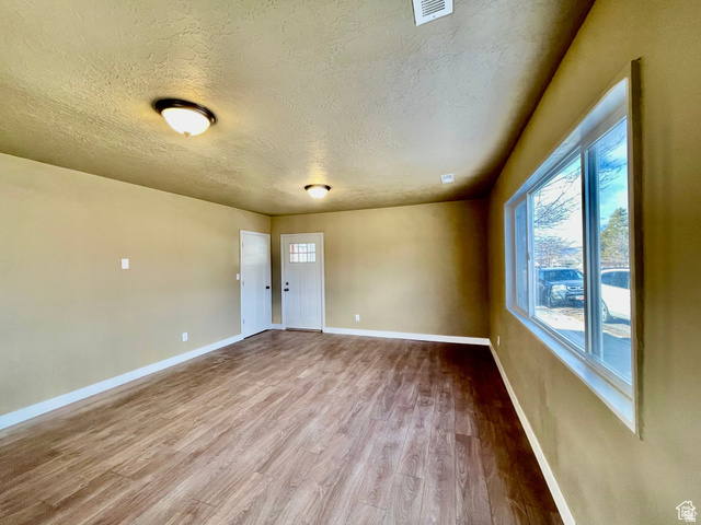 255 West Main Street Mount Pleasant, UT 84647 - Photo 9 of 35 Open interior space featuring wood-finish flooring, neutral-toned walls, and a large window