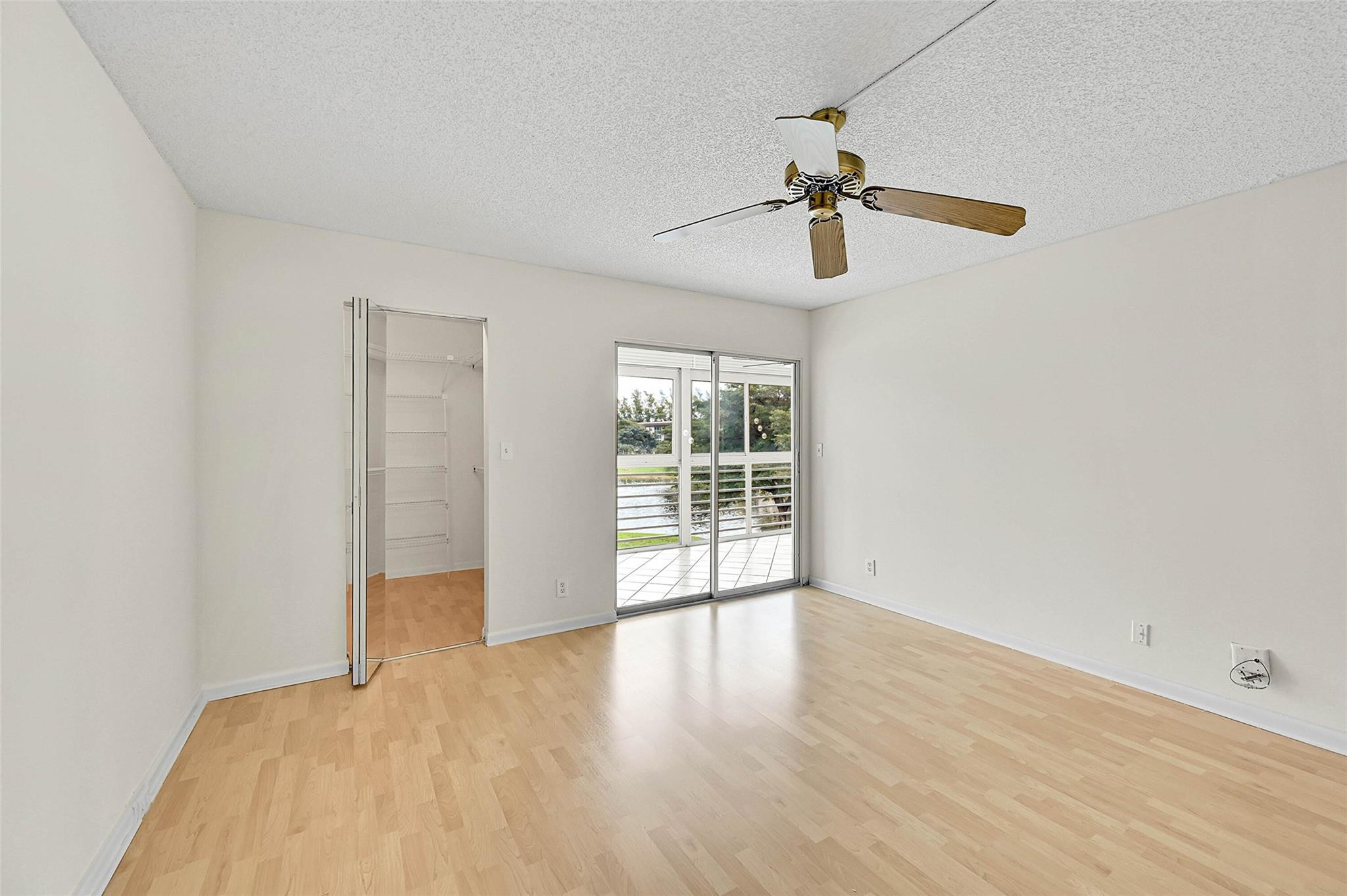 1804 Eleuthera Point, Unit E3 Coconut Creek, FL 33066 - Photo 19 of 41 a view of an empty room with wooden floor ceiling fan