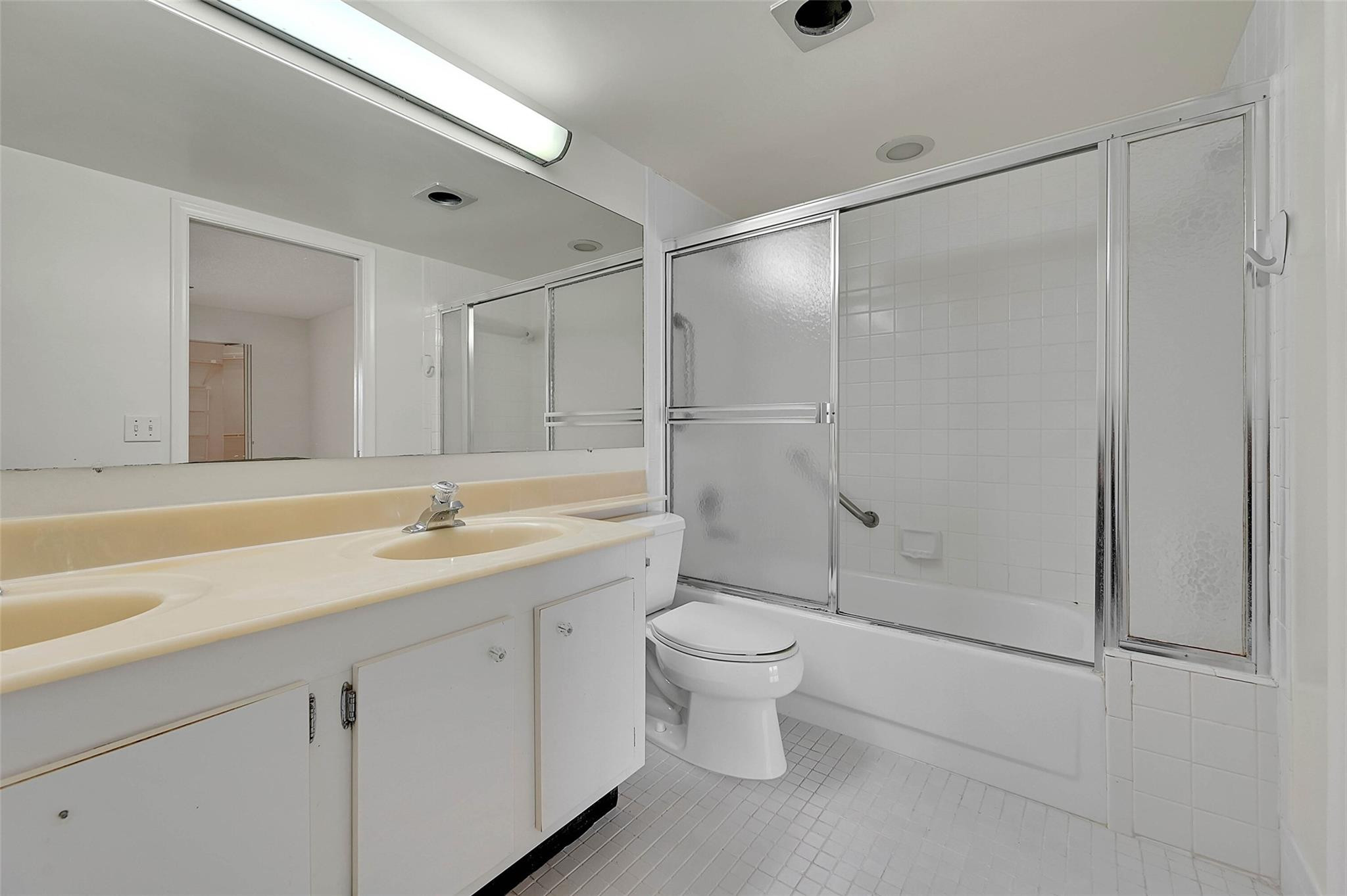 1804 Eleuthera Point, Unit E3 Coconut Creek, FL 33066 - Photo 20 of 41 a bathroom with a shower sink vanity mirror and toilet