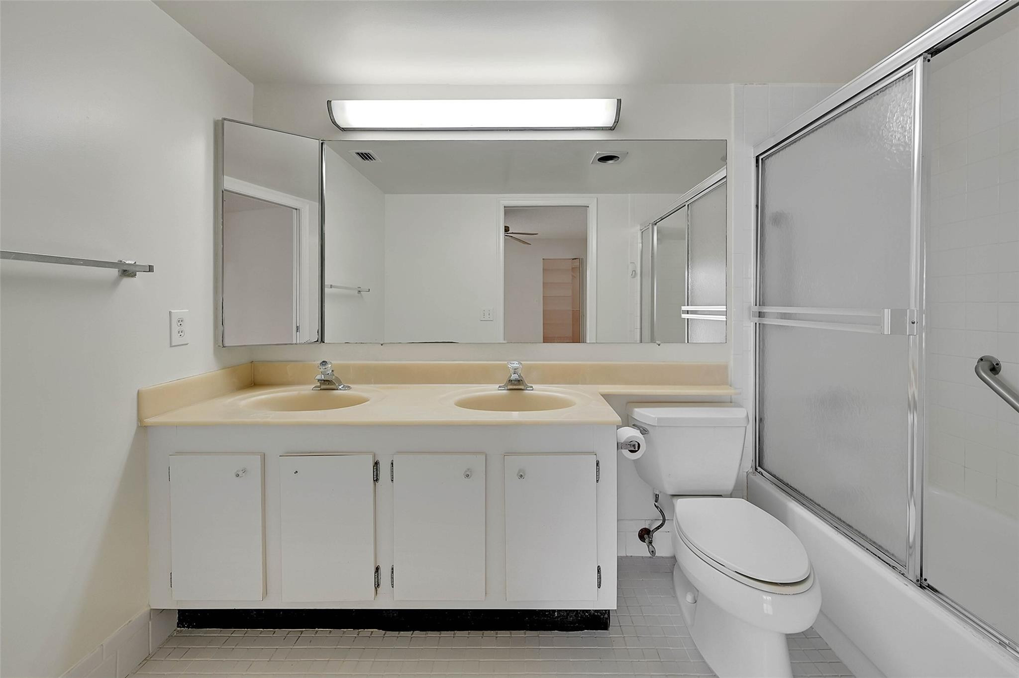 1804 Eleuthera Point, Unit E3 Coconut Creek, FL 33066 - Photo 21 of 41 a bathroom with a toilet a sink and mirror