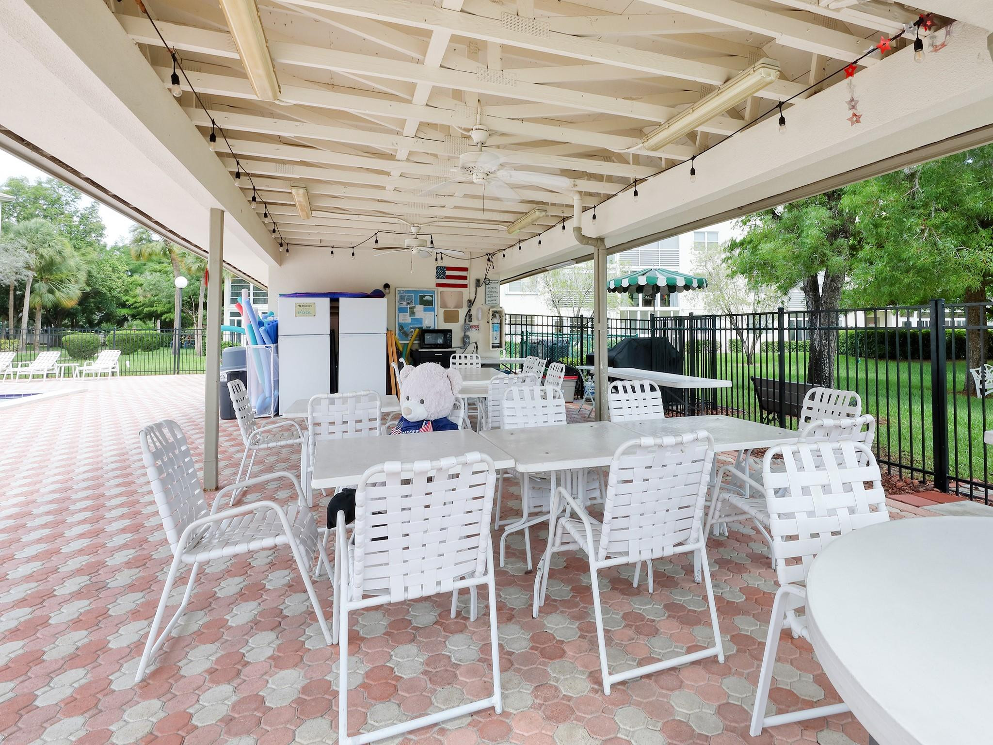 1804 Eleuthera Point, Unit E3 Coconut Creek, FL 33066 - Photo 30 of 41 a view of a patio with a table chairs and a backyard
