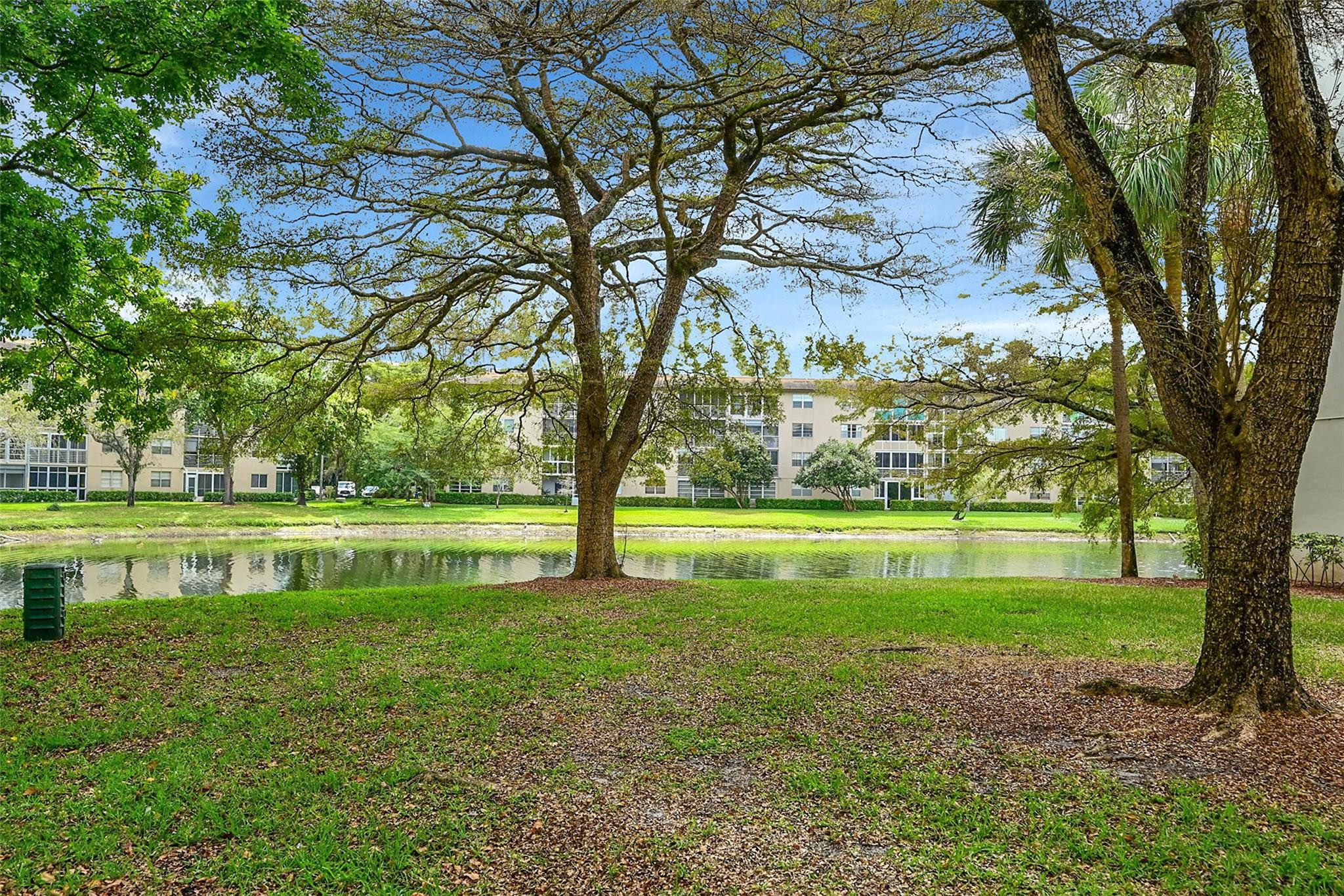 1804 Eleuthera Point, Unit E3 Coconut Creek, FL 33066 - Photo 36 of 41 a view of swimming pool with a garden and trees