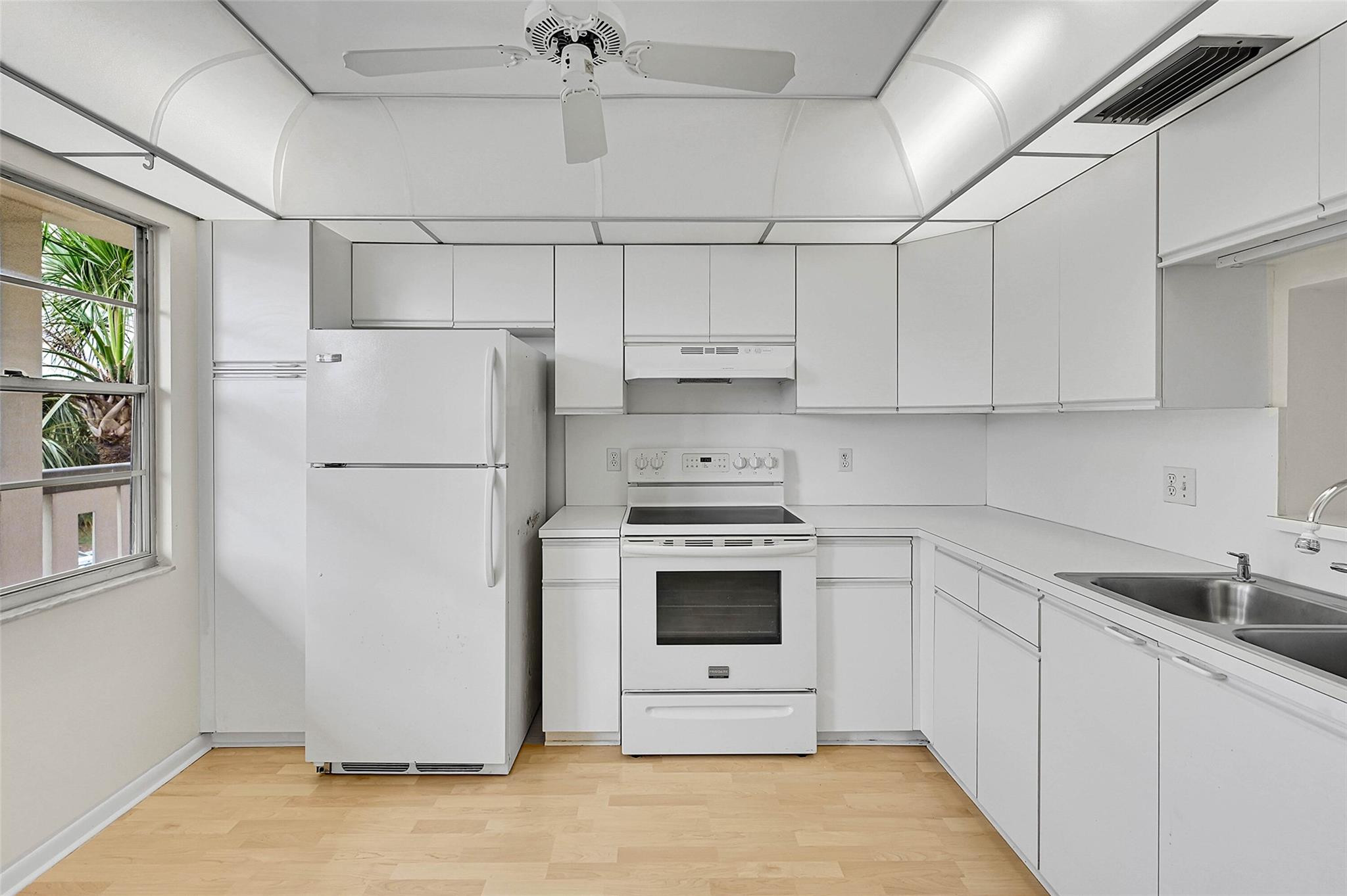 1804 Eleuthera Point, Unit E3 Coconut Creek, FL 33066 - Photo 4 of 41 a kitchen with cabinets a refrigerator and a sink