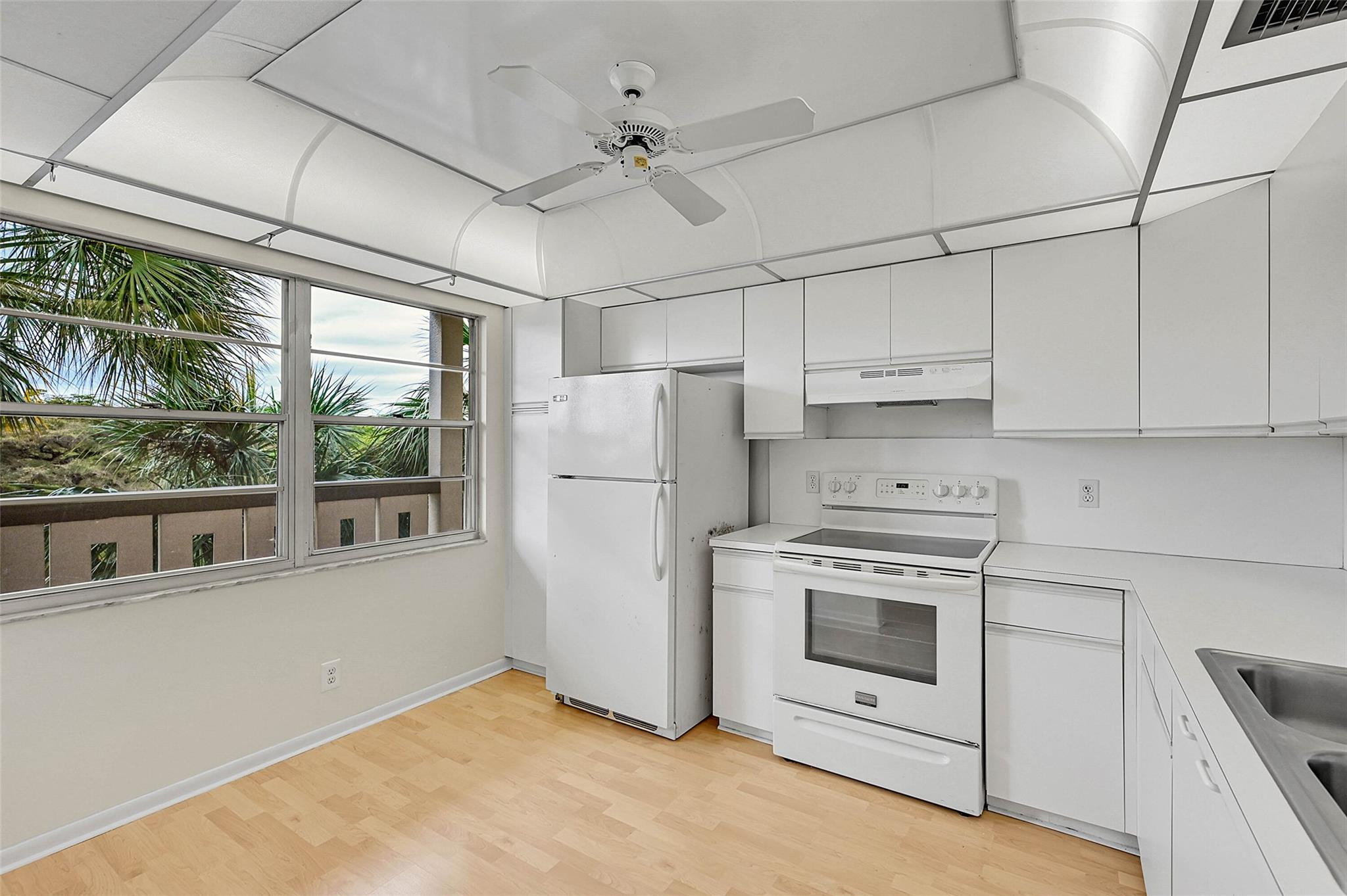 1804 Eleuthera Point, Unit E3 Coconut Creek, FL 33066 - Photo 5 of 41 a kitchen with white cabinets and white appliances