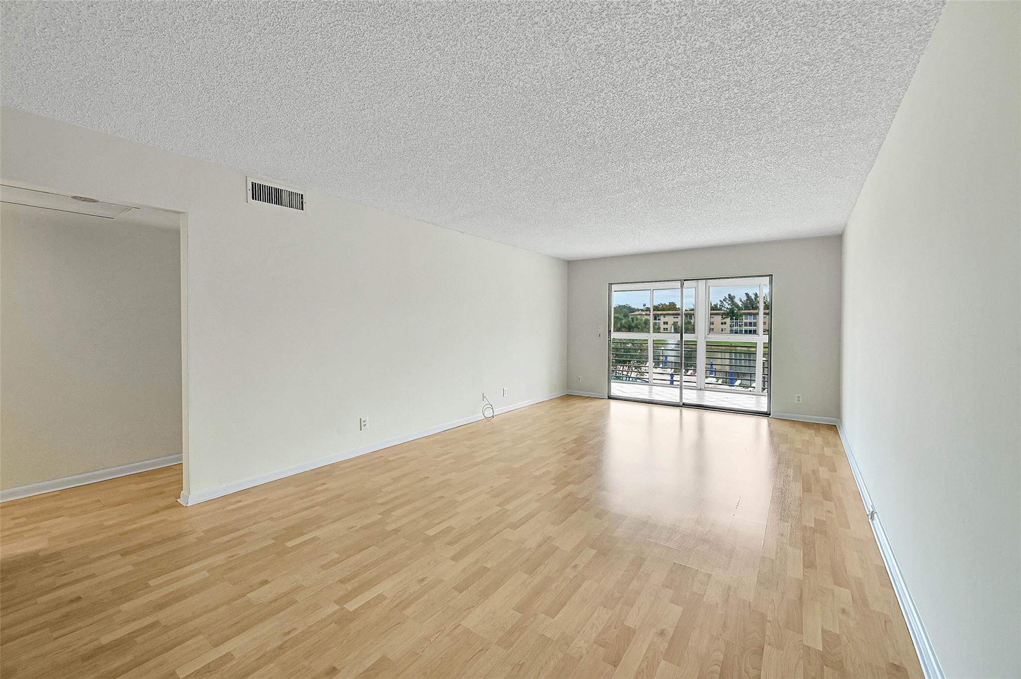 1804 Eleuthera Point, Unit E3 Coconut Creek, FL 33066 - Photo 8 of 41 wooden floor in an empty room with a window
