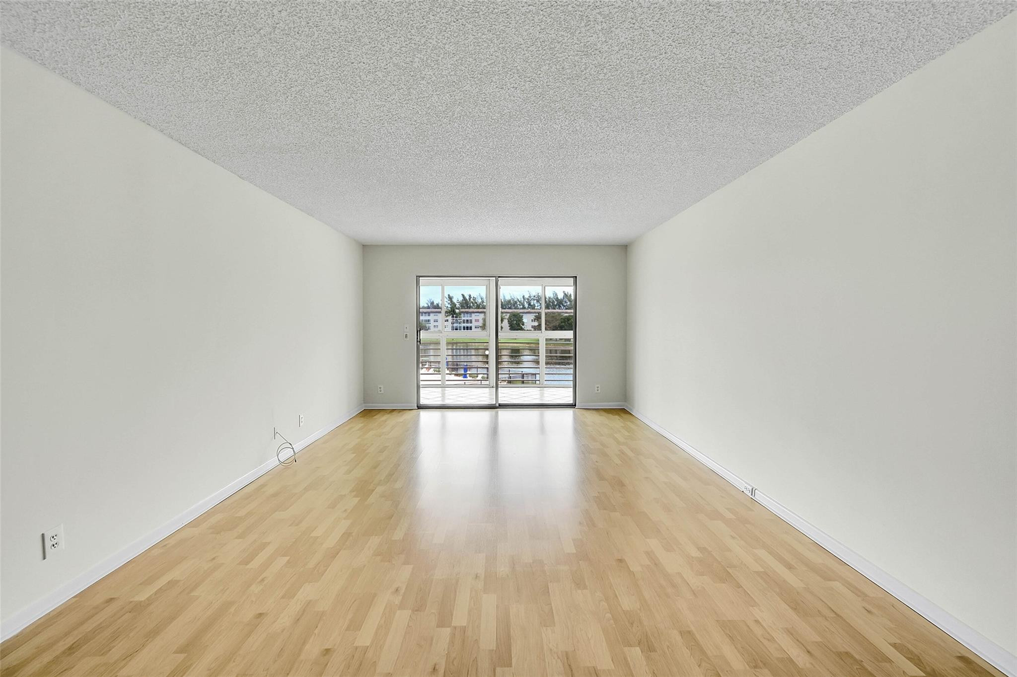 1804 Eleuthera Point, Unit E3 Coconut Creek, FL 33066 - Photo 9 of 41 wooden floor in an empty room with a window
