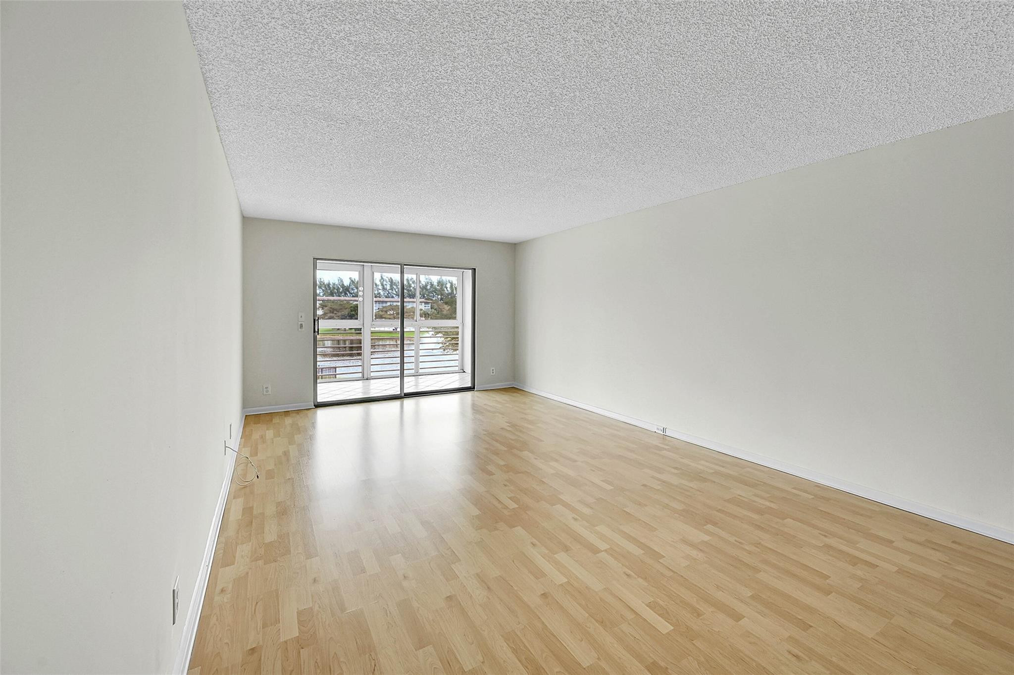 1804 Eleuthera Point, Unit E3 Coconut Creek, FL 33066 - Photo 10 of 41 wooden floor in an empty room with a window