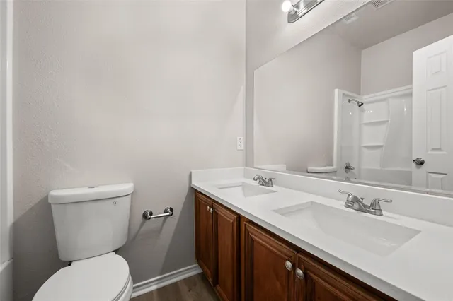 a bathroom with a granite countertop toilet sink and mirror
