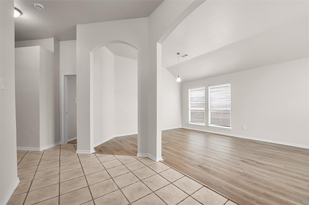 7928 Hill Country Lane Dallas, TX 75249 - Photo 5 of 19 a view of an empty room with wooden floor and a window