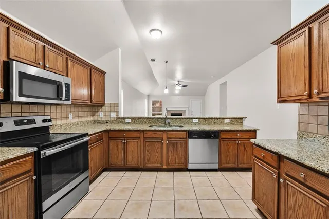 a kitchen with stainless steel appliances granite countertop a sink and stove top oven